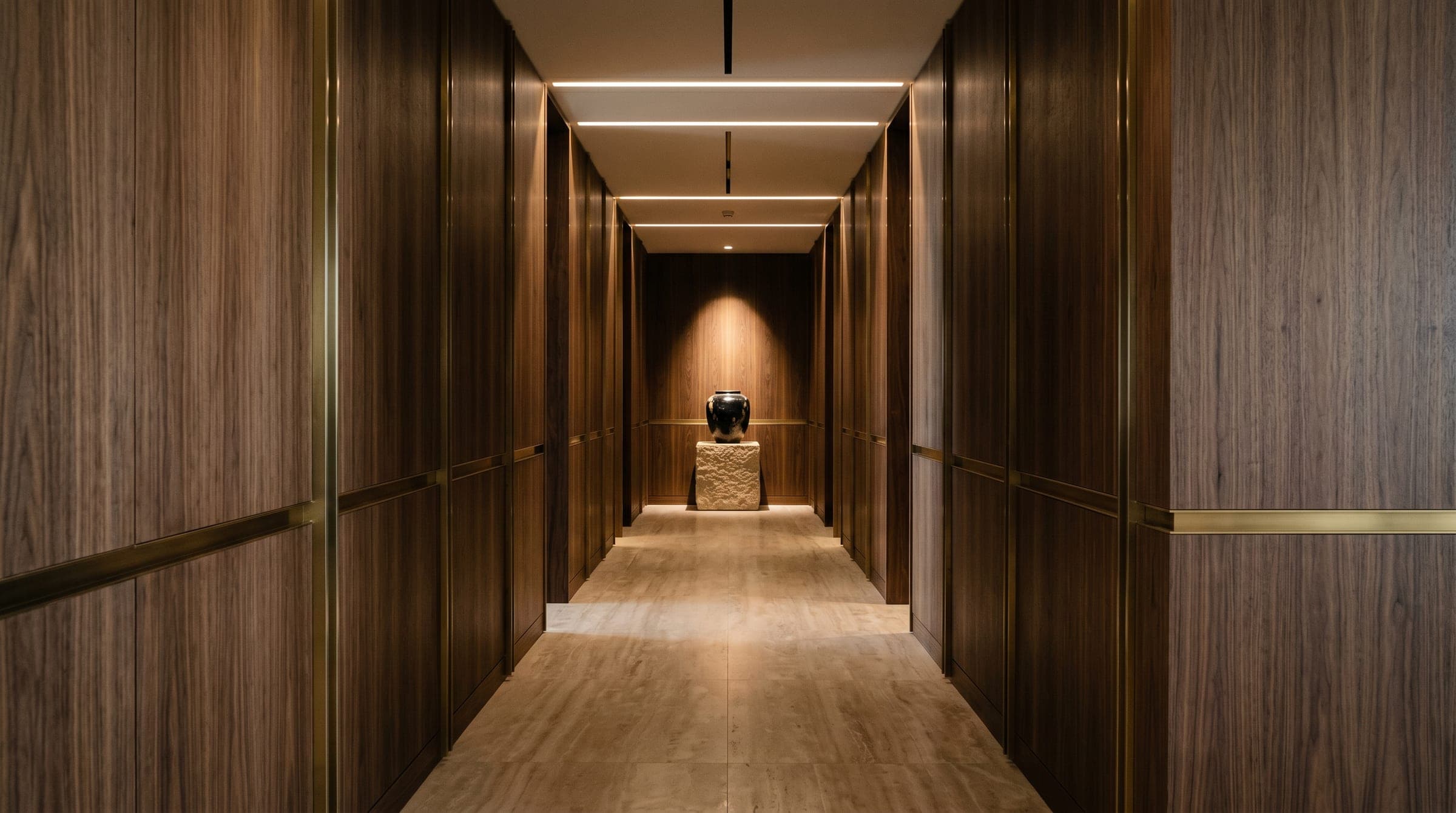 An arrival corridor lined in walnut