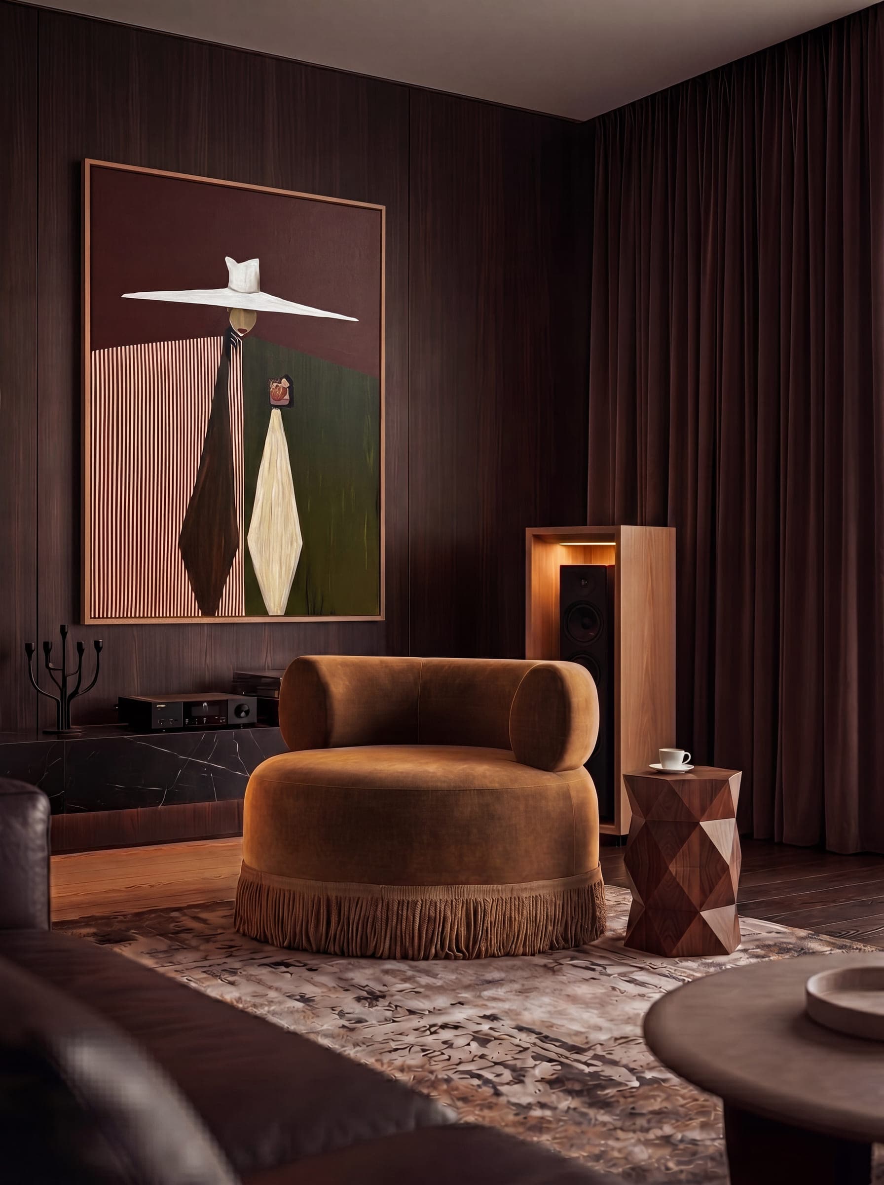A sitting room resolved in one palette: a fringed velvet armchair on a patterned rug, a faceted side table and a framed artwork against dark timber walls — interior design by LKYOOB