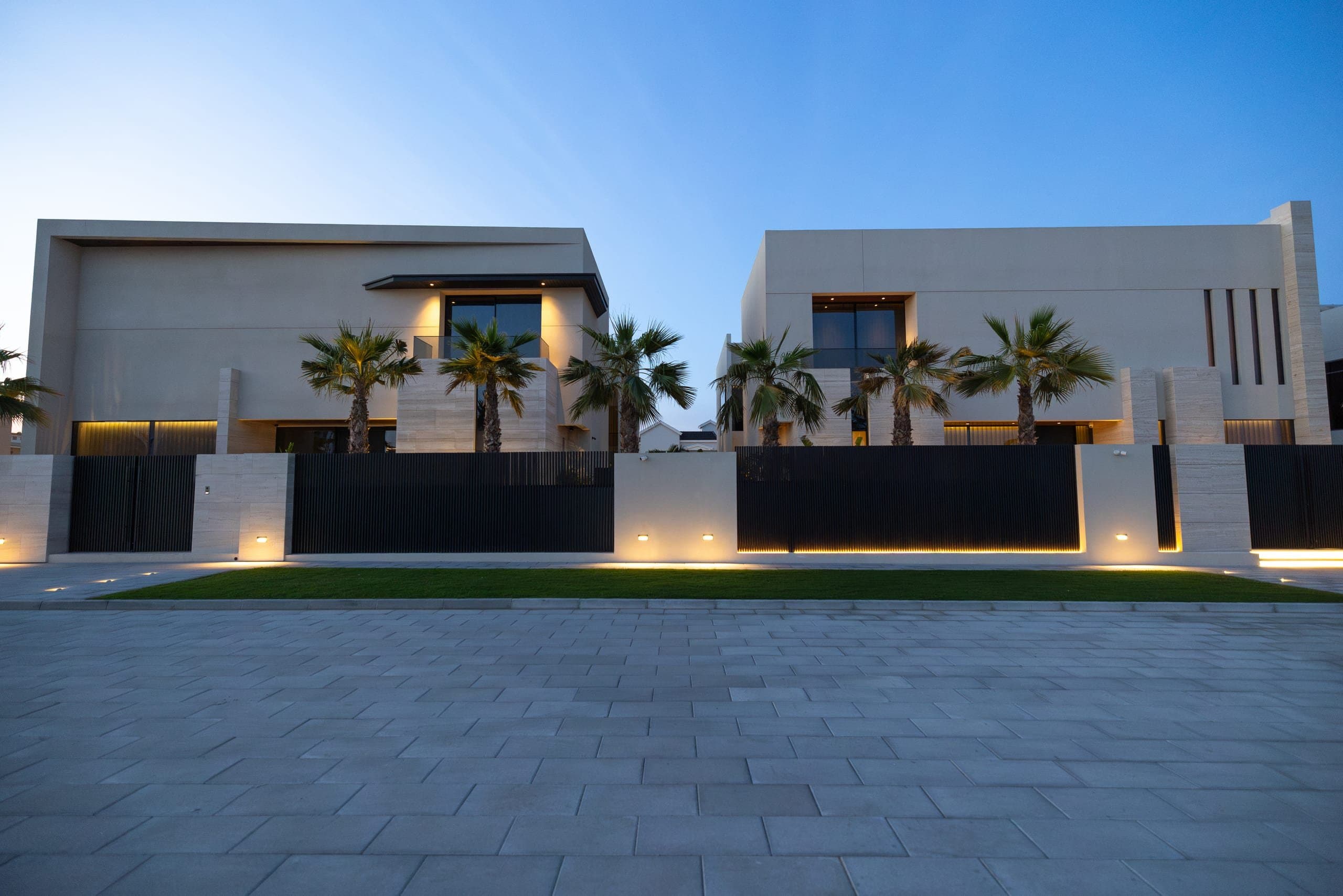 Villas at dusk along a palm lined driveway