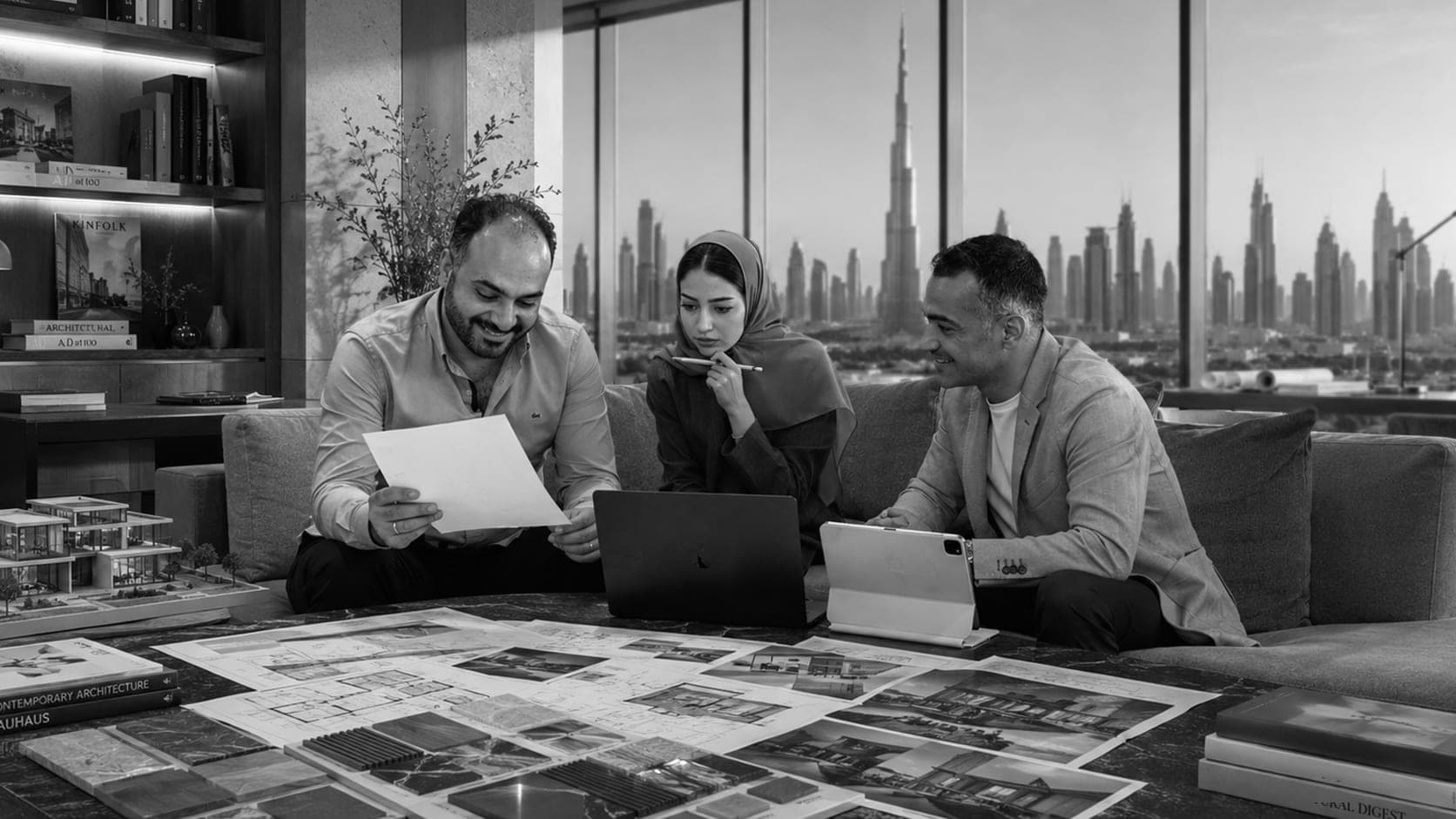 The LKYOOB team reviewing residential plans and architectural models above the Dubai skyline — senior architects and designers
