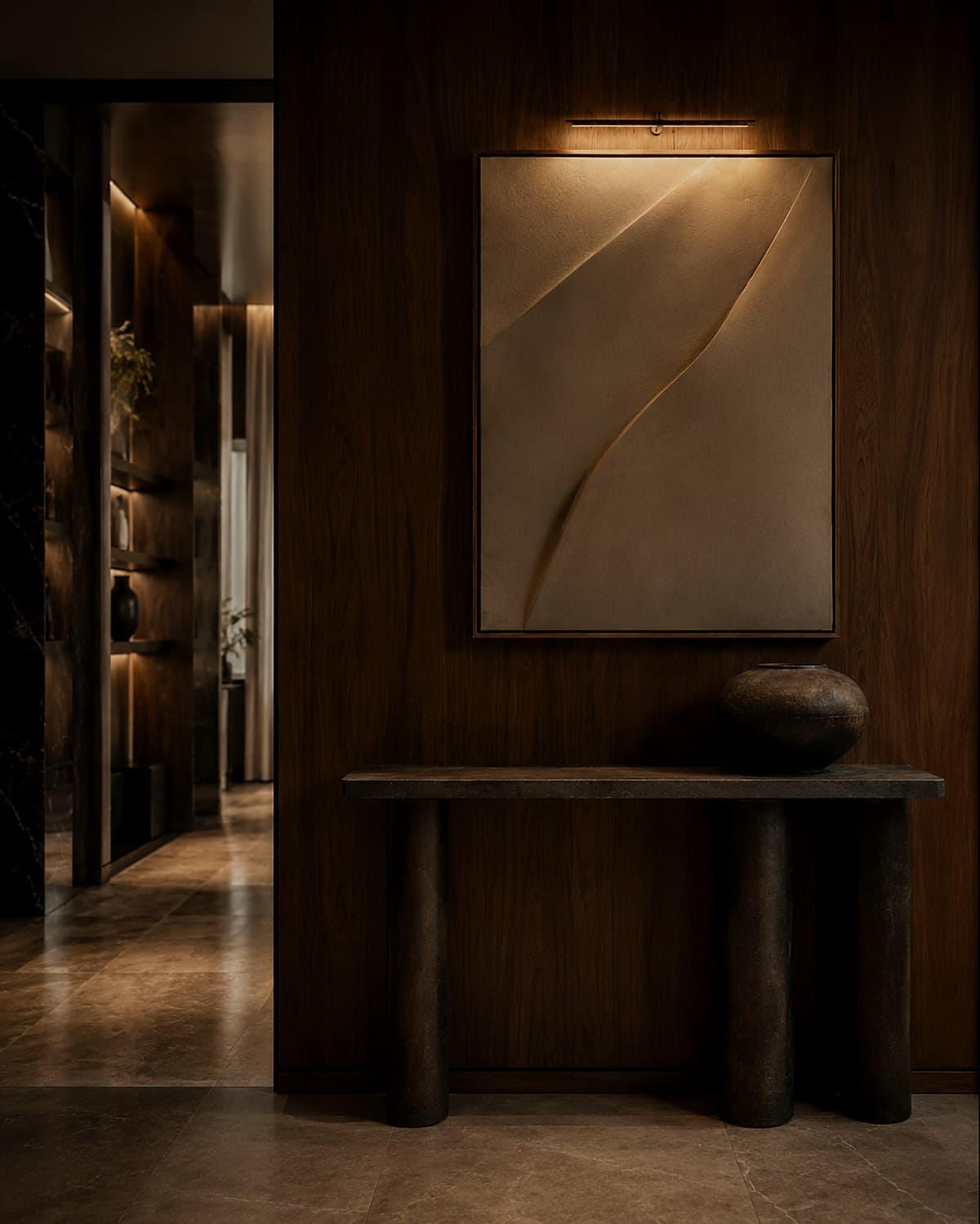A hallway with a walnut console and hung artwork