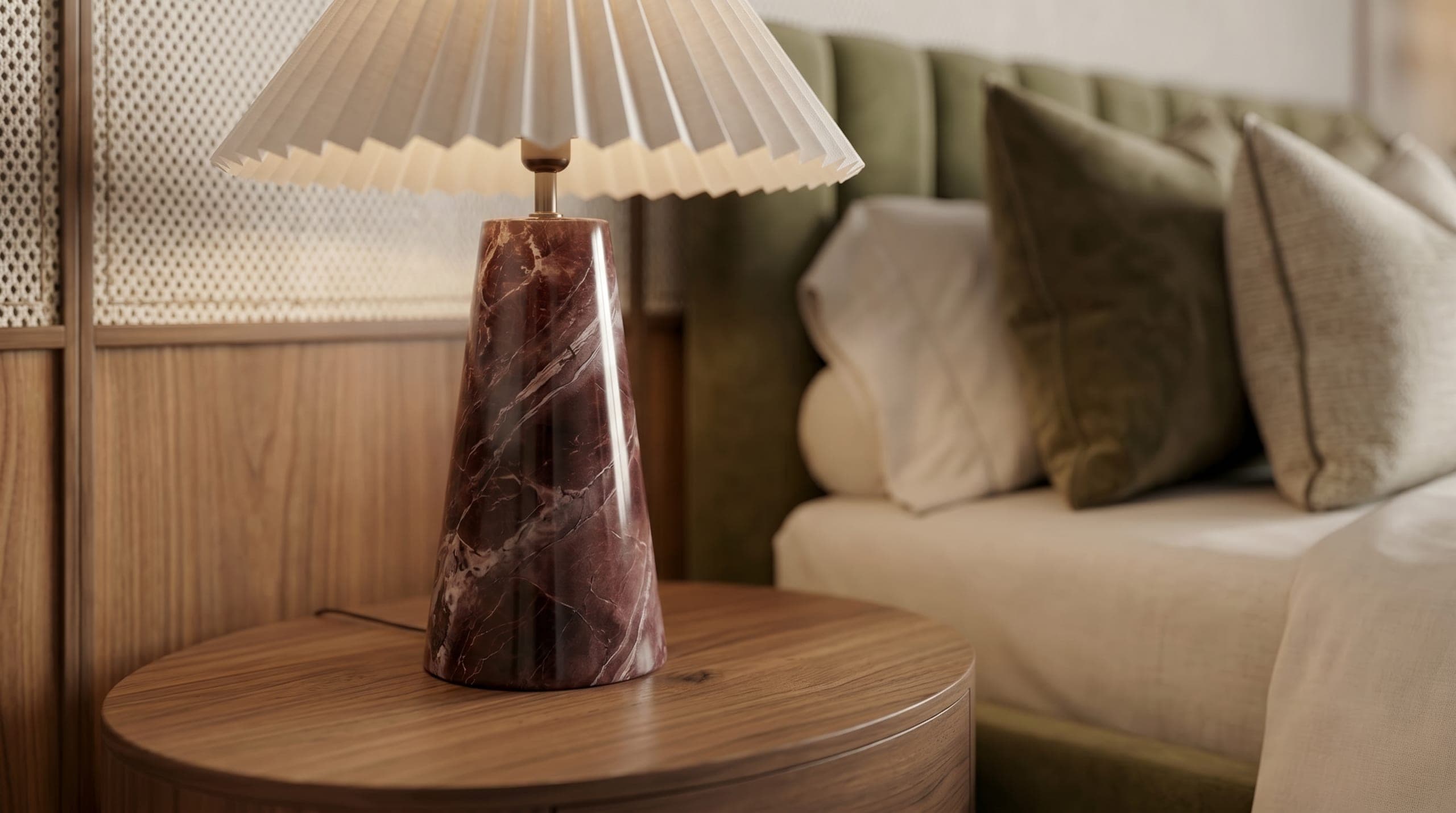 A bedside with a red marble lamp against a green headboard