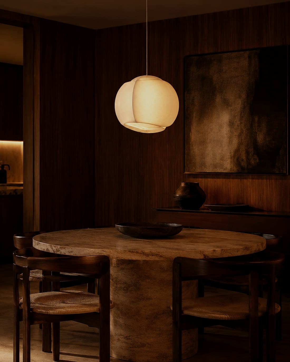A dining room lit by a pendant over the table