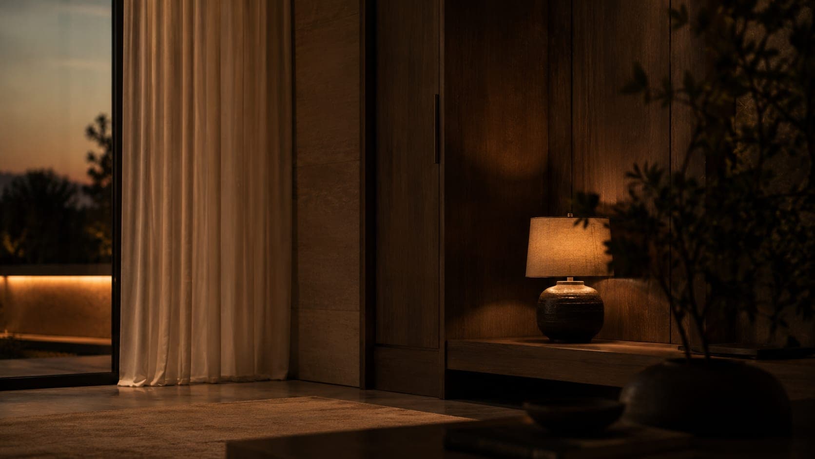 A furnished corner at dusk with drapery and a lamp
