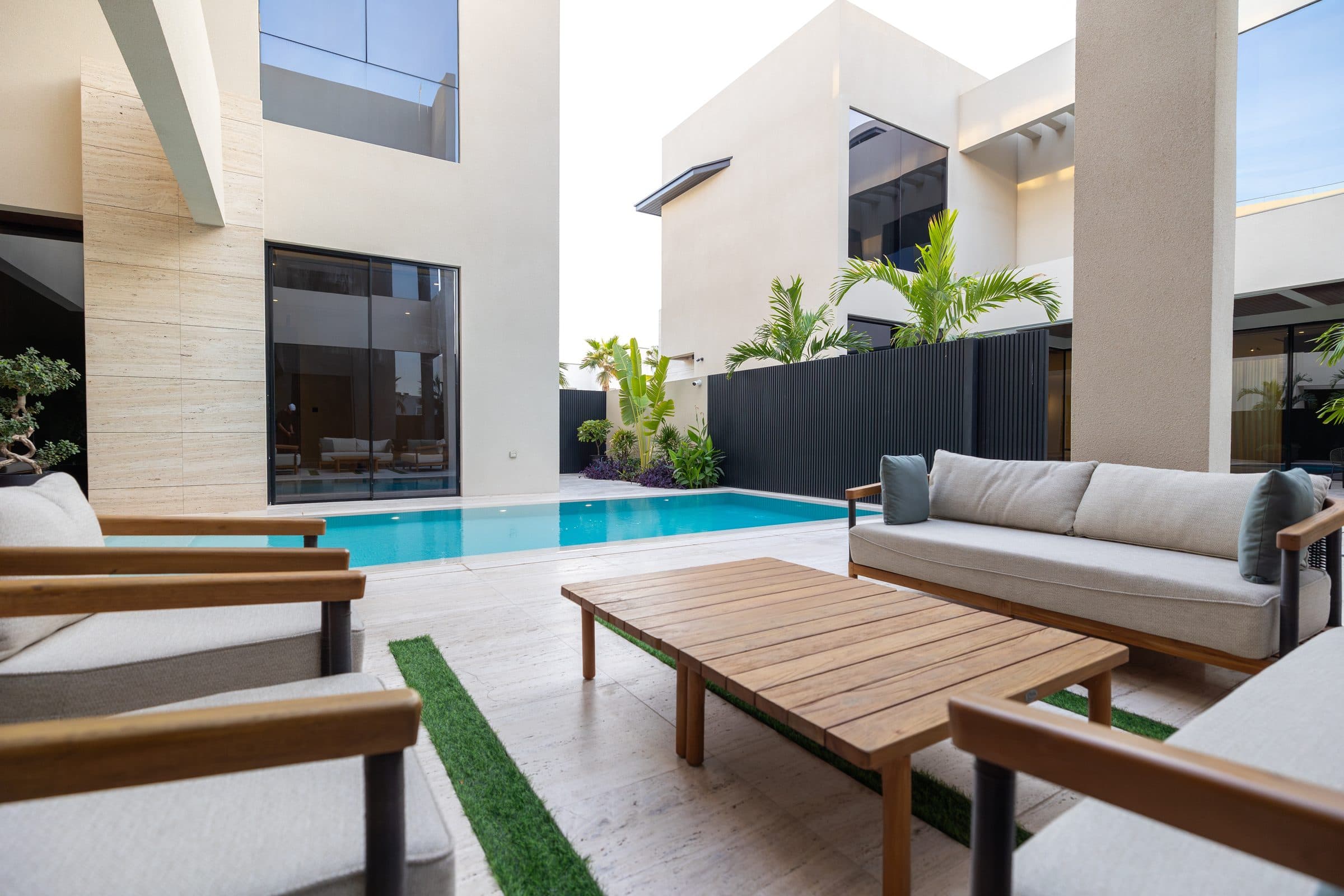 Timber outdoor lounge seating beside the pool at The Travertine Villas, a LKYOOB commission